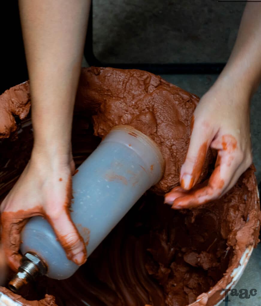 Showing the filling of the cartridge with clay